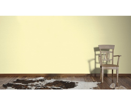 Salon avec parquet, tapis en peau de vache, une chaise et un mur clair