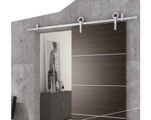 Porte coulissante avec surface en acier et kit de montage devant un mur en béton