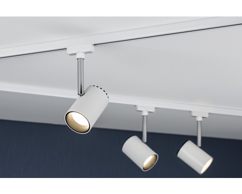 Drei weisse Strahler sind an einer Schiene an der Decke befestigt und spenden Licht.