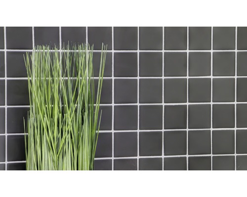 Plante artificielle décorative devant un mur de carreaux