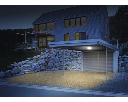 Beleuchtetes Carport an einem modernen Wohnhaus mit Steintreppe