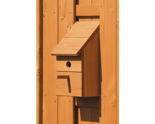 Holz-Nistkasten mit Einflugloch an einer Holzwand montiert