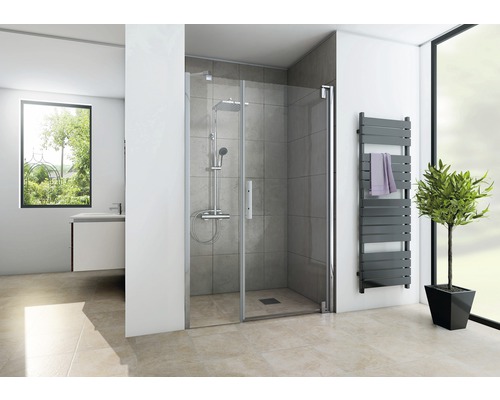 Salle de bain avec douche, sèche-serviettes et fenêtre pour une ambiance lumineuse.