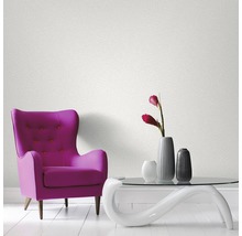 Pièce avec fauteuil, table et papier peint au mur