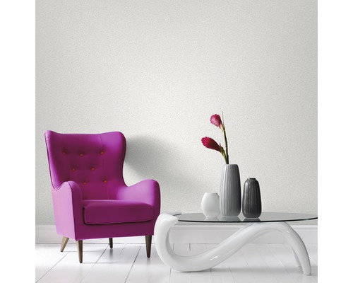 Pièce avec fauteuil, table et papier peint au mur