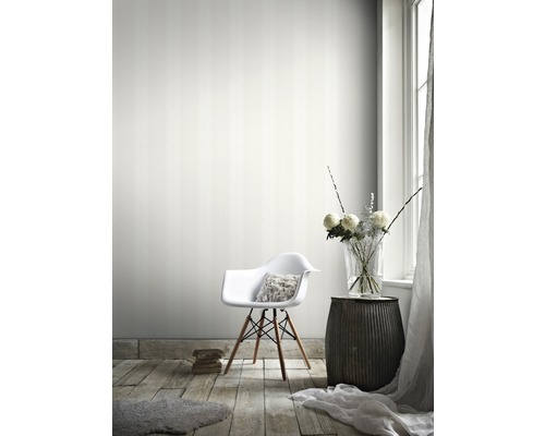 Salon avec papier peint rayé, chaise, table d''appoint et vase de fleurs