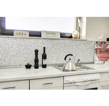 Scène de cuisine avec carrelage mosaïque, cuisinière et articles de décoration