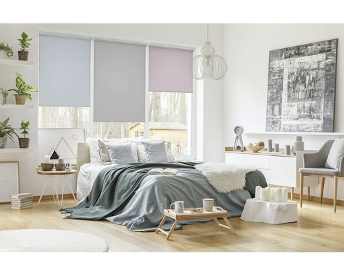 Helles Schlafzimmer mit Fensterrollos und verschiedenen Dekorationsgegenständen
