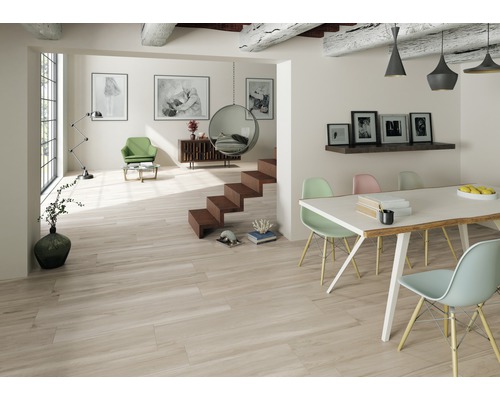 Espace de vie lumineux avec carrelage imitation bois, table à manger et escalier