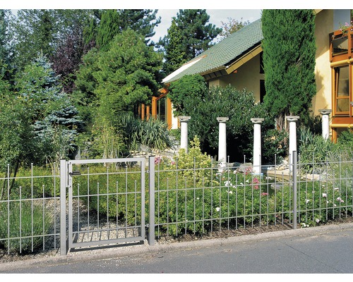 Scène avec une clôture métallique grise et un portail de jardin devant une maison avec jardin