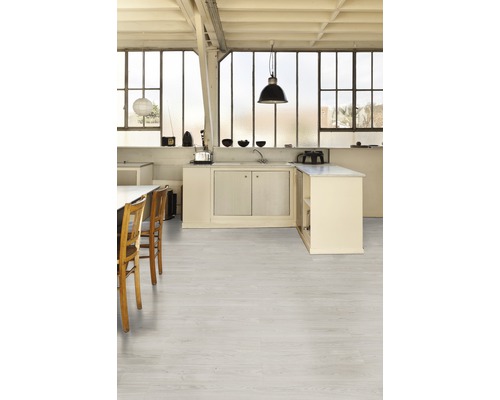 Pièce lumineuse avec cuisine design, table à manger et plancher en bois clair.