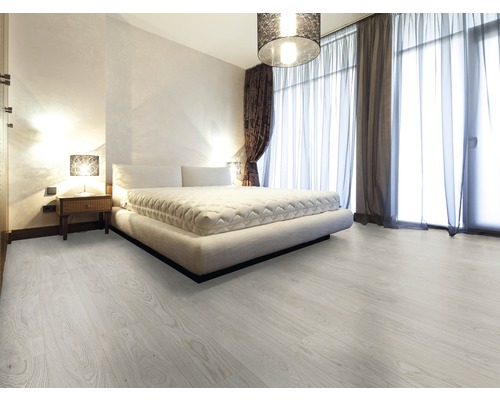 Chambre lumineuse avec lit, rideaux et plancher en bois