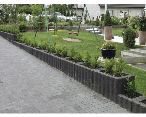 Jardin aménagé avec pelouse, chemin pavé, bordures de gazon et aire de jeux