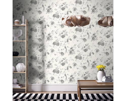 Salon décoratif avec papier peint à motifs floraux, étagère en bois, table en bois et suspensions