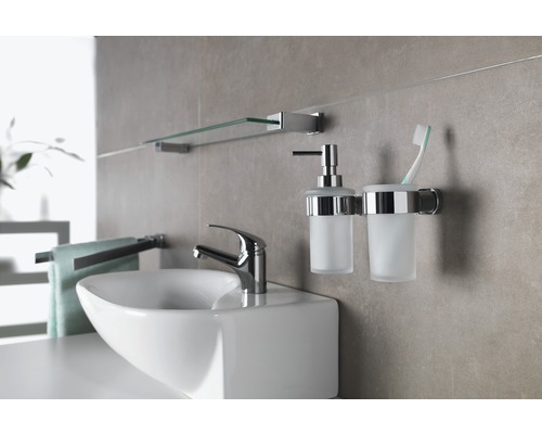 Badezimmer mit Waschbecken, Armatur, Seifenspender, Zahnputzbecher und Ablage