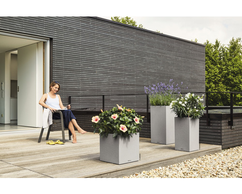 Terrasse mit Pflanzkübeln und entspannender Frau