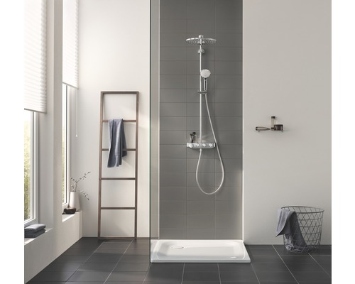 Badezimmer mit Duschsystem, Duschwanne, Handtuchhalter und Ablagefläche