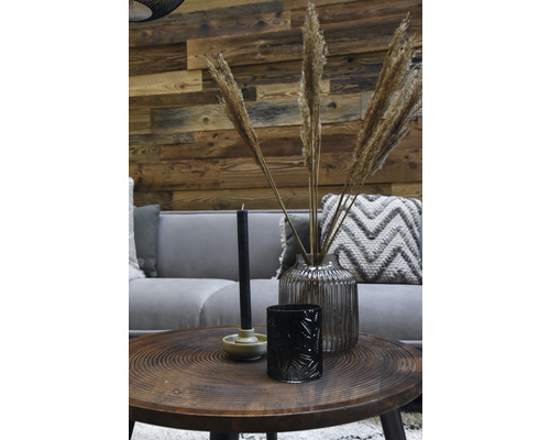 Salon décoratif avec canapé, table et accessoires tels que bougies, photophore et vase avec graminées ornementales