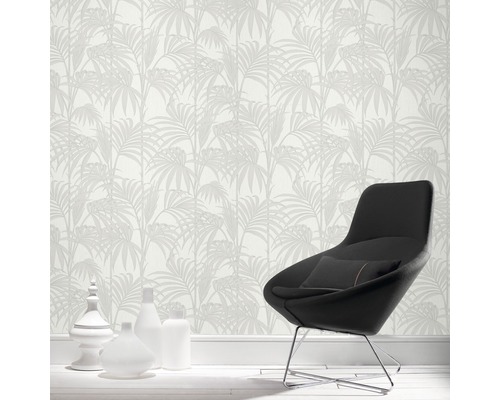 Innenraum mit gemusterter Tapete, Sessel und dekorativen Vasen