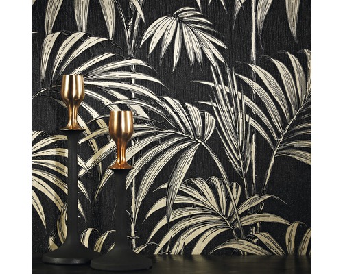 Deux chandeliers devant un papier peint à motif de palmiers.