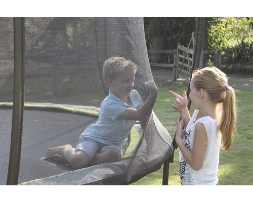 Zwei Kinder spielen auf einem Gartentrampolin mit Sicherheitsnetz