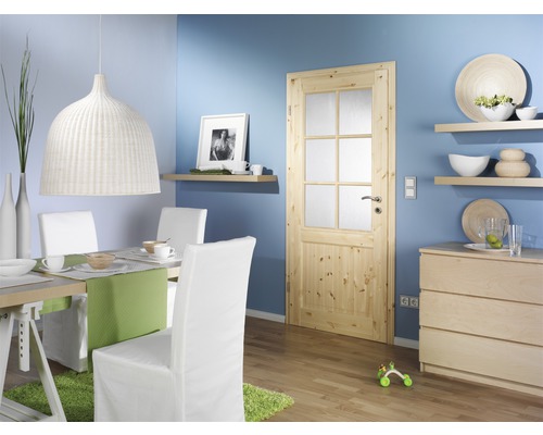 Heller Essbereich mit Holztür, Esstisch, Stühlen und Kommode