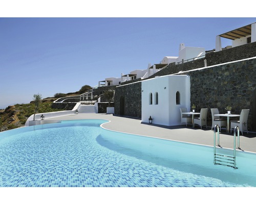 Aussenansicht eines Hotels mit Pool, Sitzgelegenheiten und weisser Fassade