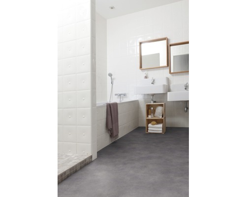 Salle de bains lumineuse avec baignoire, lavabos et sol gris