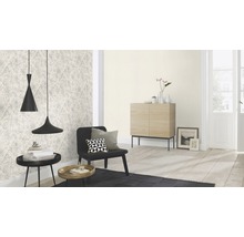 Wohnzimmer mit gemusterter Tapete, schwarzem Sessel und zwei Pendelleuchten