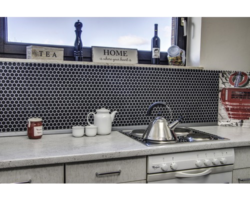 Küchenszene mit Mosaikfliesen, Teekanne, Wasserkocher und Kochfeld.