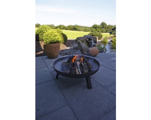 Feuerstelle mit brennendem Holz im Gartenbereich