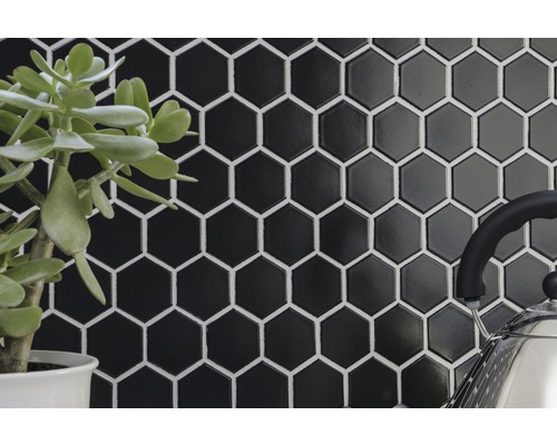 Carreaux hexagonaux noirs brillants avec joints blancs en arrière-plan.