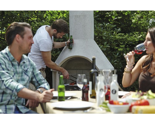 Des personnes font des grillades sur un barbecue de jardin et sont assises à une table à manger