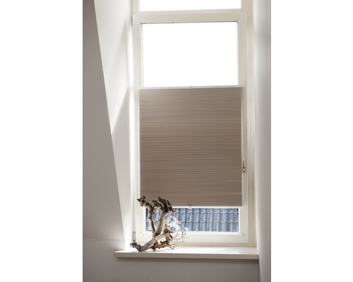 Store plissé beige à la fenêtre pour protection solaire et décoration