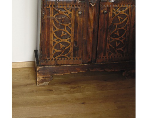 Detail eines Holzschranks mit geschnitzten Türen auf einem Holzboden