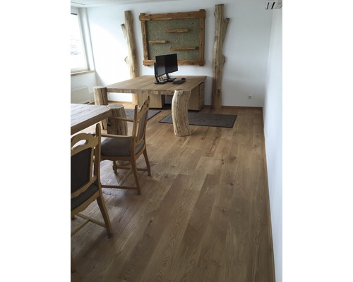 Büro mit Massivholztisch, Baumstamm-Elementen und Holzfussboden