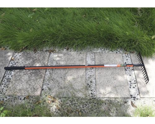 Râteau de jardin avec manche sur pavés