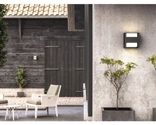 Aussenbereich mit quadratischer Wandleuchte, Gartenmöbeln und Bepflanzung