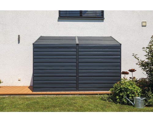 Coffre de rangement en plastique dans le jardin devant un mur de maison