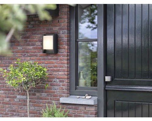 Aussenwandleuchte an einer Ziegelmauer neben einer Haustür