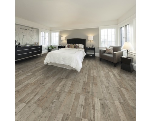 Chambre avec lit, commode, fauteuil et plancher en bois