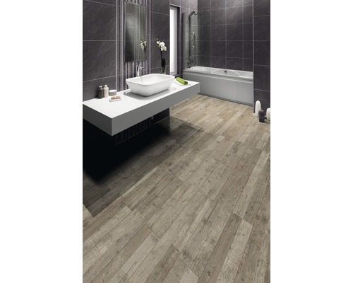 Salle de bain avec baignoire, lavabo et carrelage de sol imitation bois