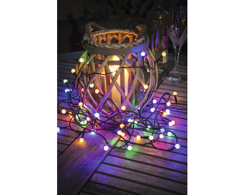 Décoration avec lanterne en bois, bougie et guirlande lumineuse sur table en bois