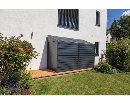 Abri de jardin métallique avec porte à côté du mur de la maison sur la pelouse