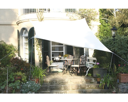 Jardin avec voile d''ombrage au-dessus d''un groupe de tables de terrasse