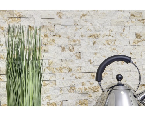 Mur en pierre décoratif avec des graminées ornementales et une bouilloire en acier inoxydable