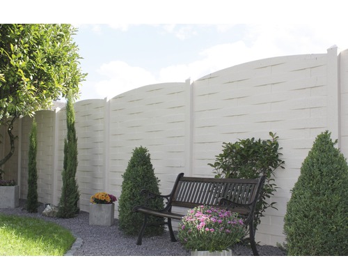 Gartenszene mit Betonzaun, Bank und Bepflanzung