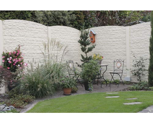 Vue du jardin avec brise-vue décoratif en béton et coin salon