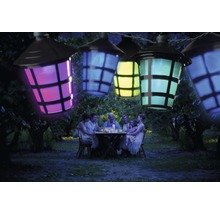 Guirlande lumineuse avec lanternes colorées au-dessus d''une famille assise dans le jardin