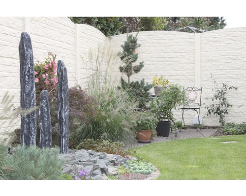 Jardin aménagé avec des pierres décoratives, des plantes et un écran d''intimité